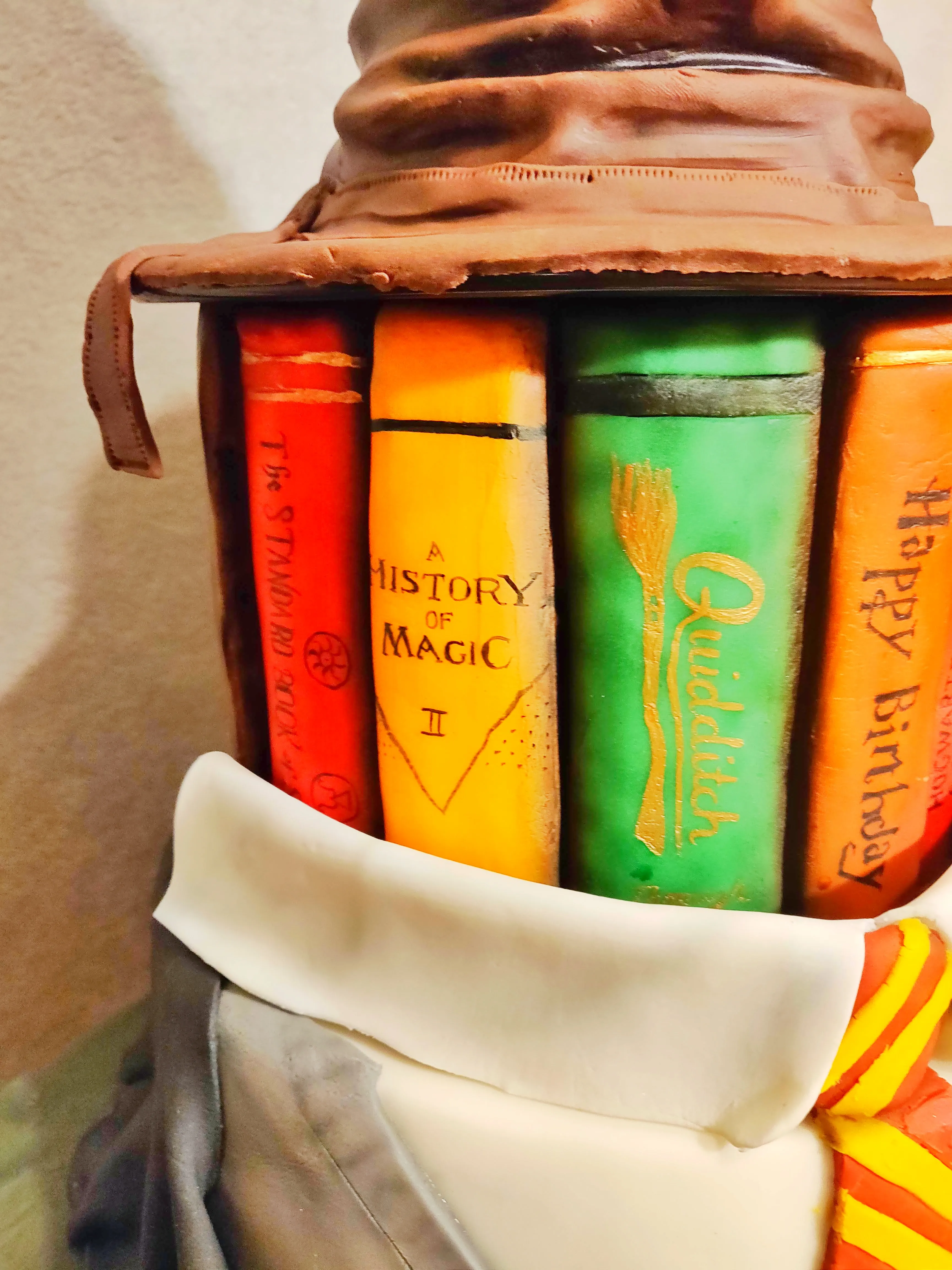 Sculpted Harry Potter book stack with History of Magic, Quidditch, brown Sorting Hat and Gryffindor scarf detail