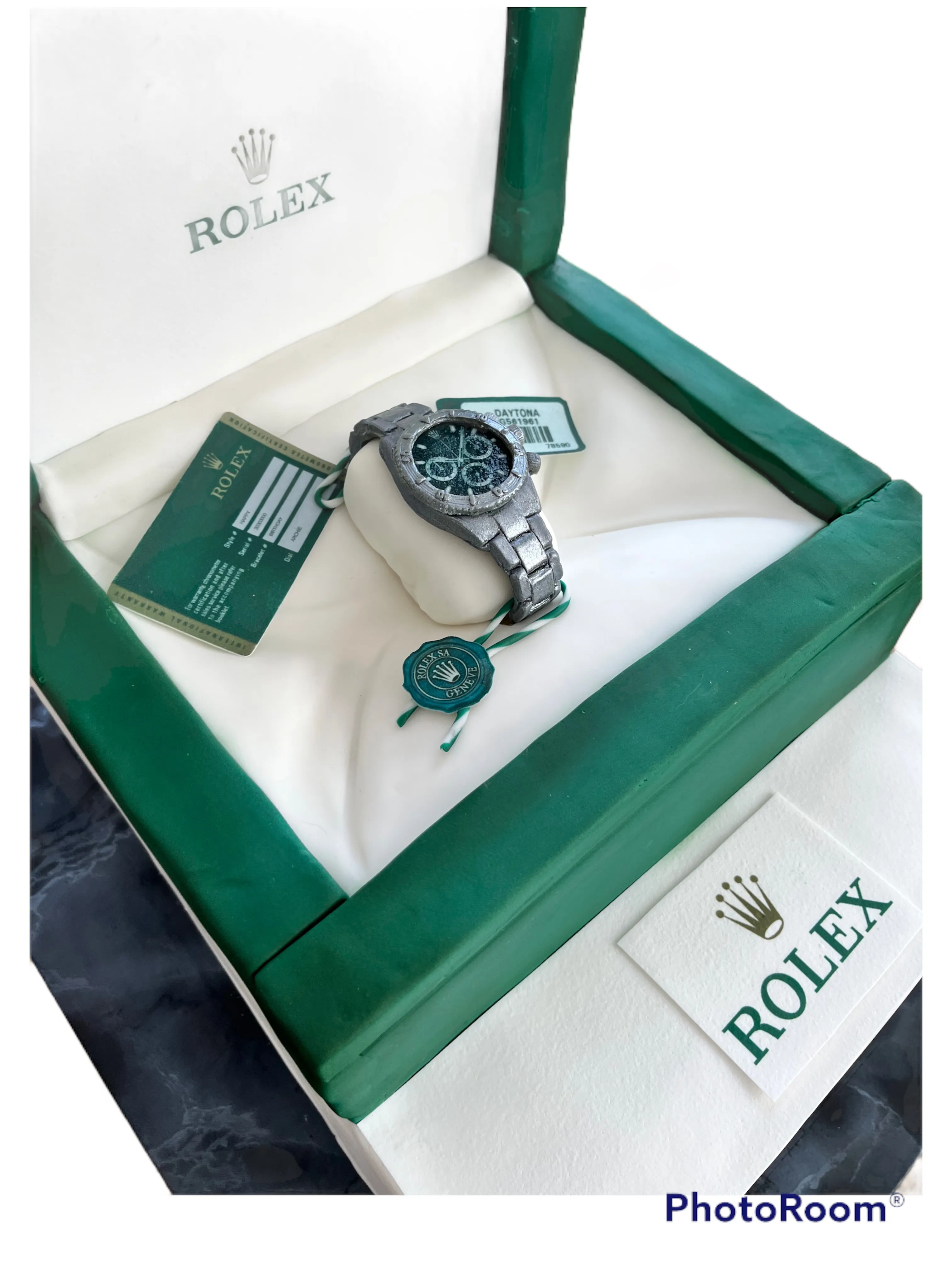Sculpted Rolex watch box cake from a second angle showing green case and silver watch detail