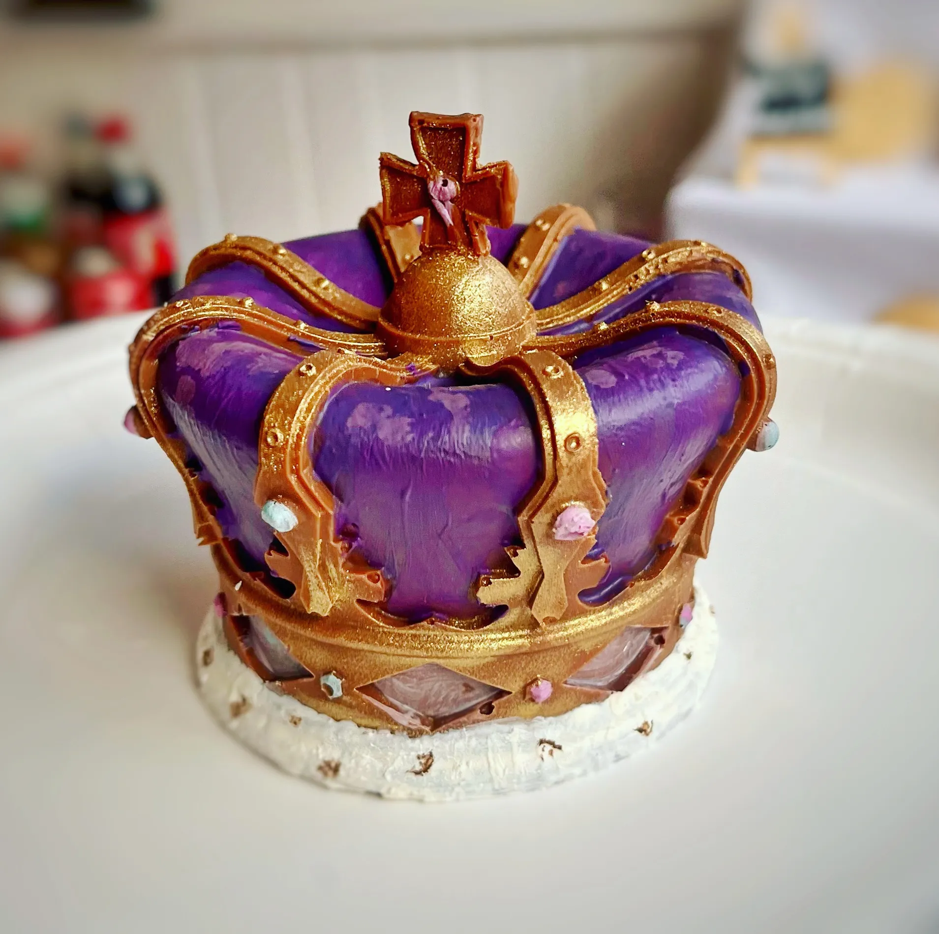 Sculpted royal crown cake in purple and gold with intricate detailing